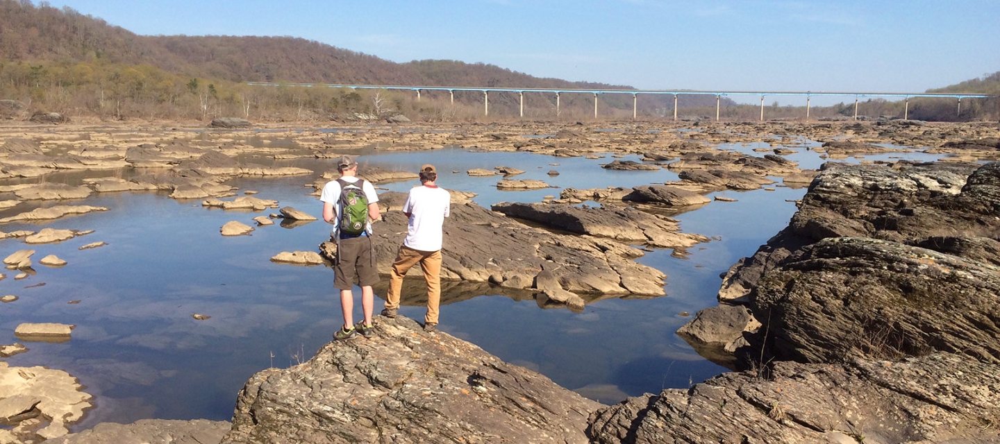 Students near a rock formation in water